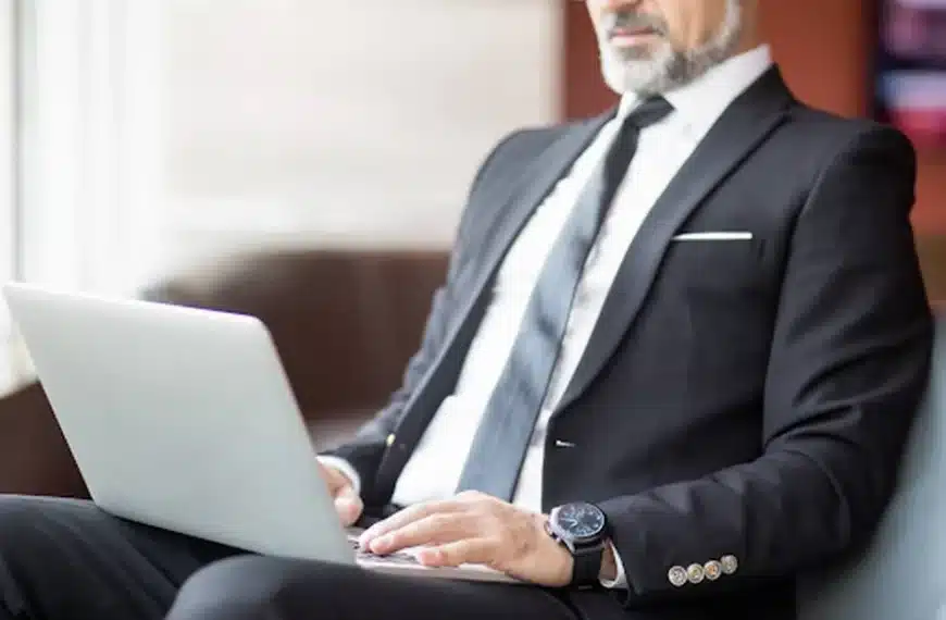 Attorney in a professional suit working on a laptop, representing best practices for optimizing attorney bio pages to increase lead conversion.