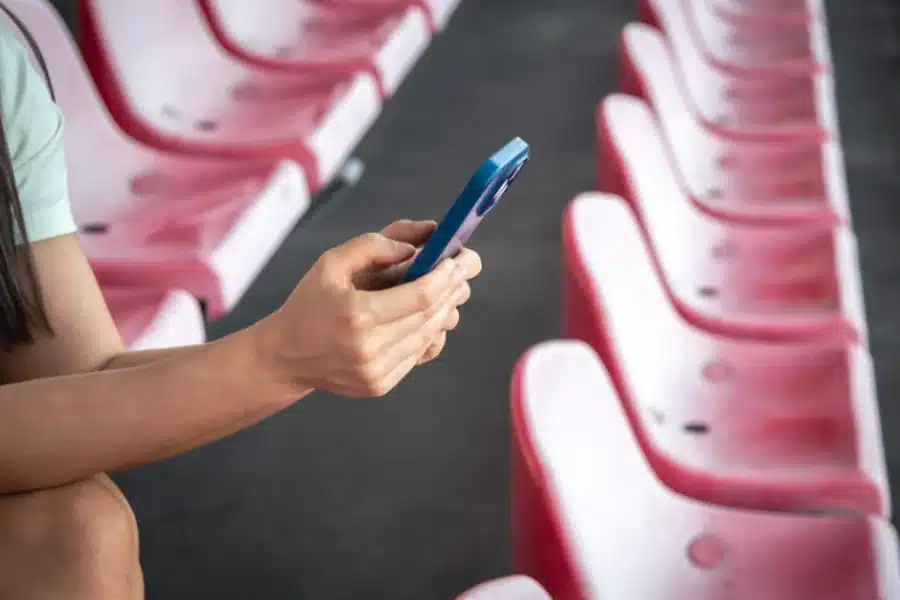 Woman uses a smartphone while sitting in the stadium
